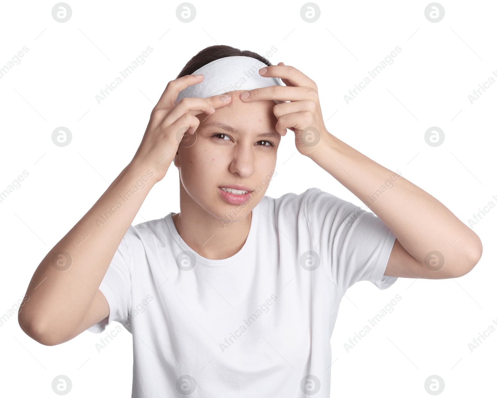 Photo of Teenage girl popping pimple on her face against white background. Acne problem