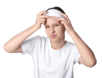 Photo of Teenage girl popping pimple on her face against white background. Acne problem