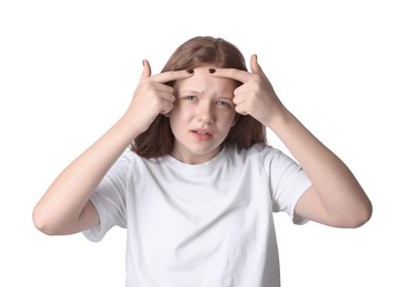 Teenage girl popping pimple on her face against white background. Acne problem