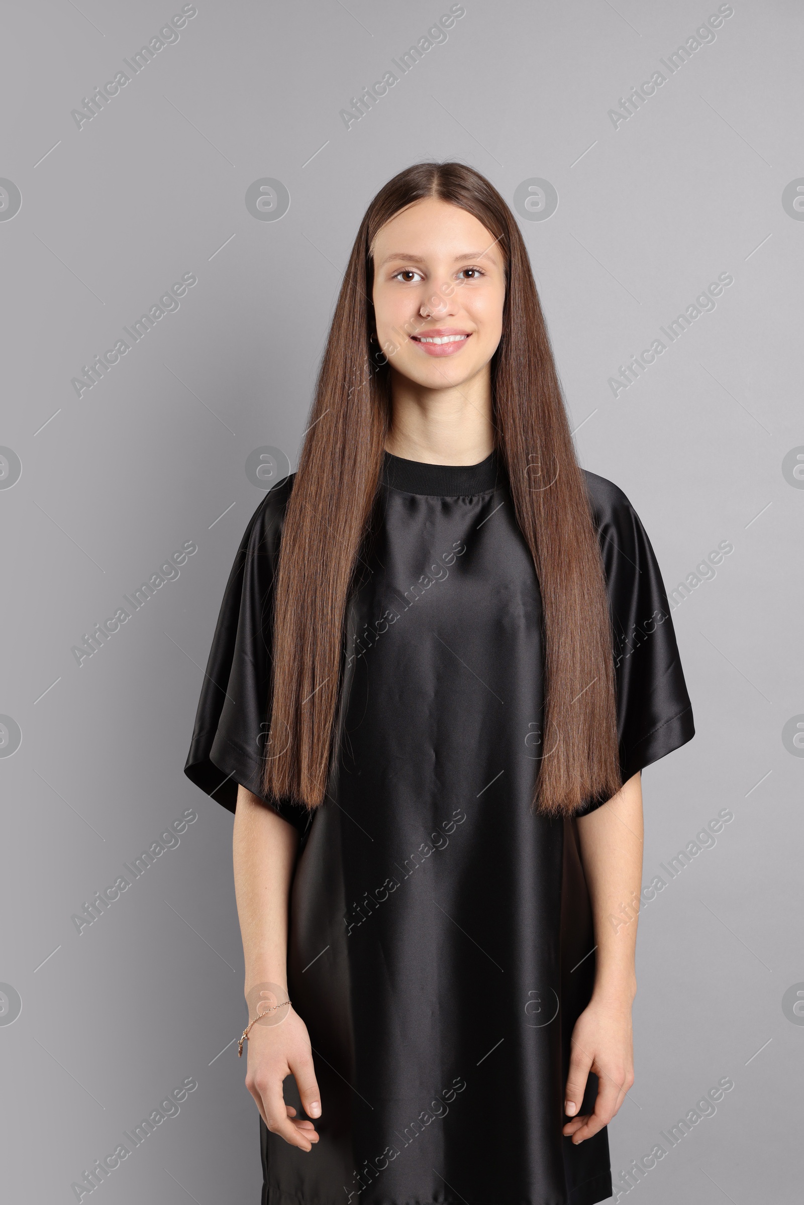 Photo of Teenage girl with healthy long hair on light grey background