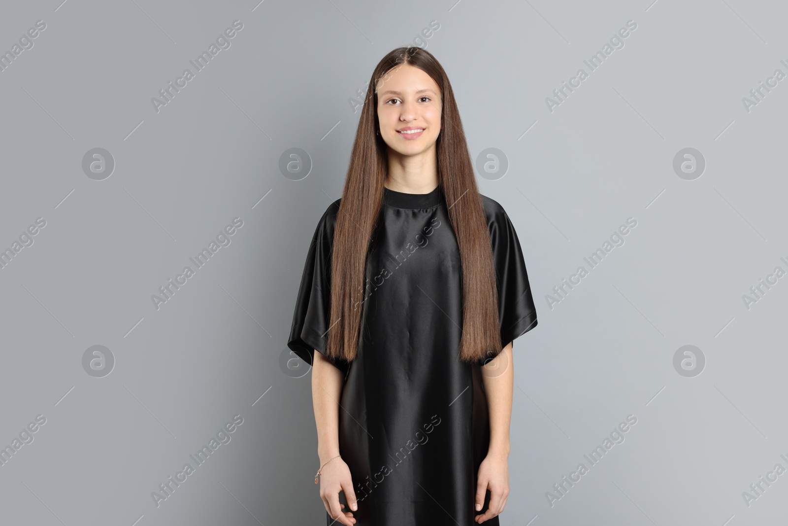 Photo of Teenage girl with healthy long hair on light grey background