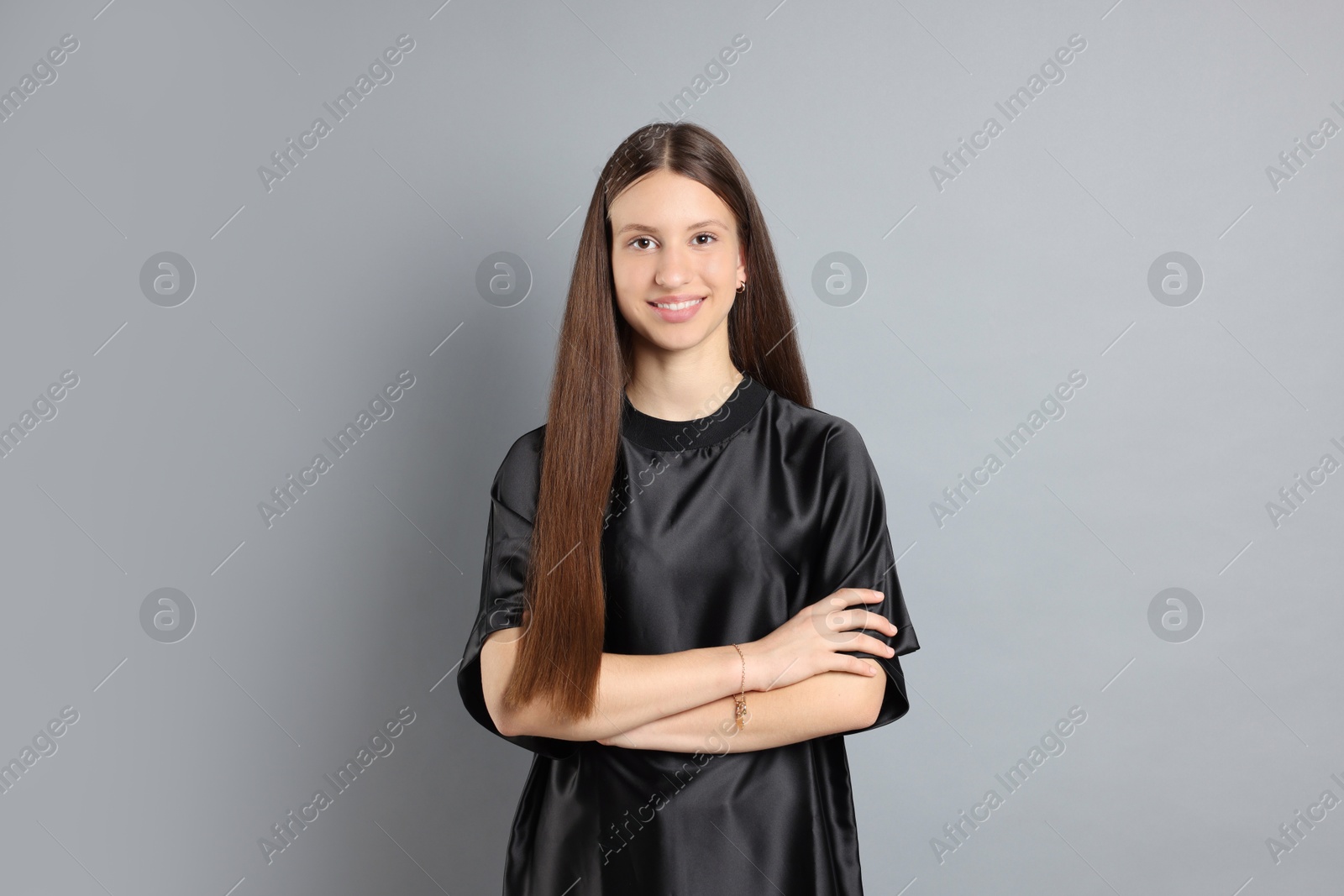 Photo of Teenage girl with healthy long hair on light grey background