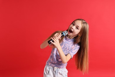 Photo of Little girl with microphone singing on red background