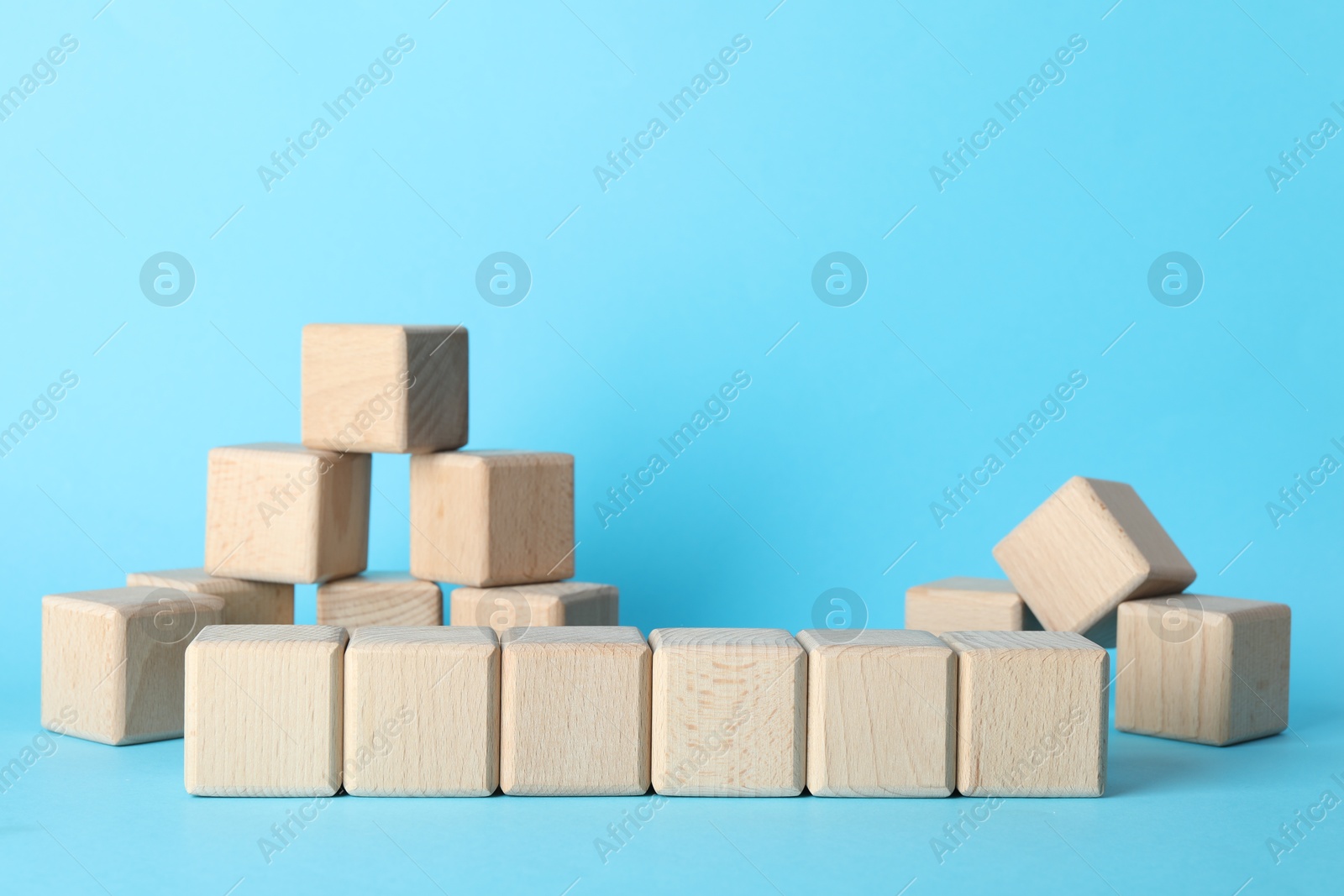 Photo of Many wooden cubes on light blue background