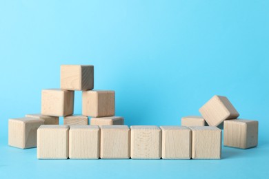 Photo of Many wooden cubes on light blue background