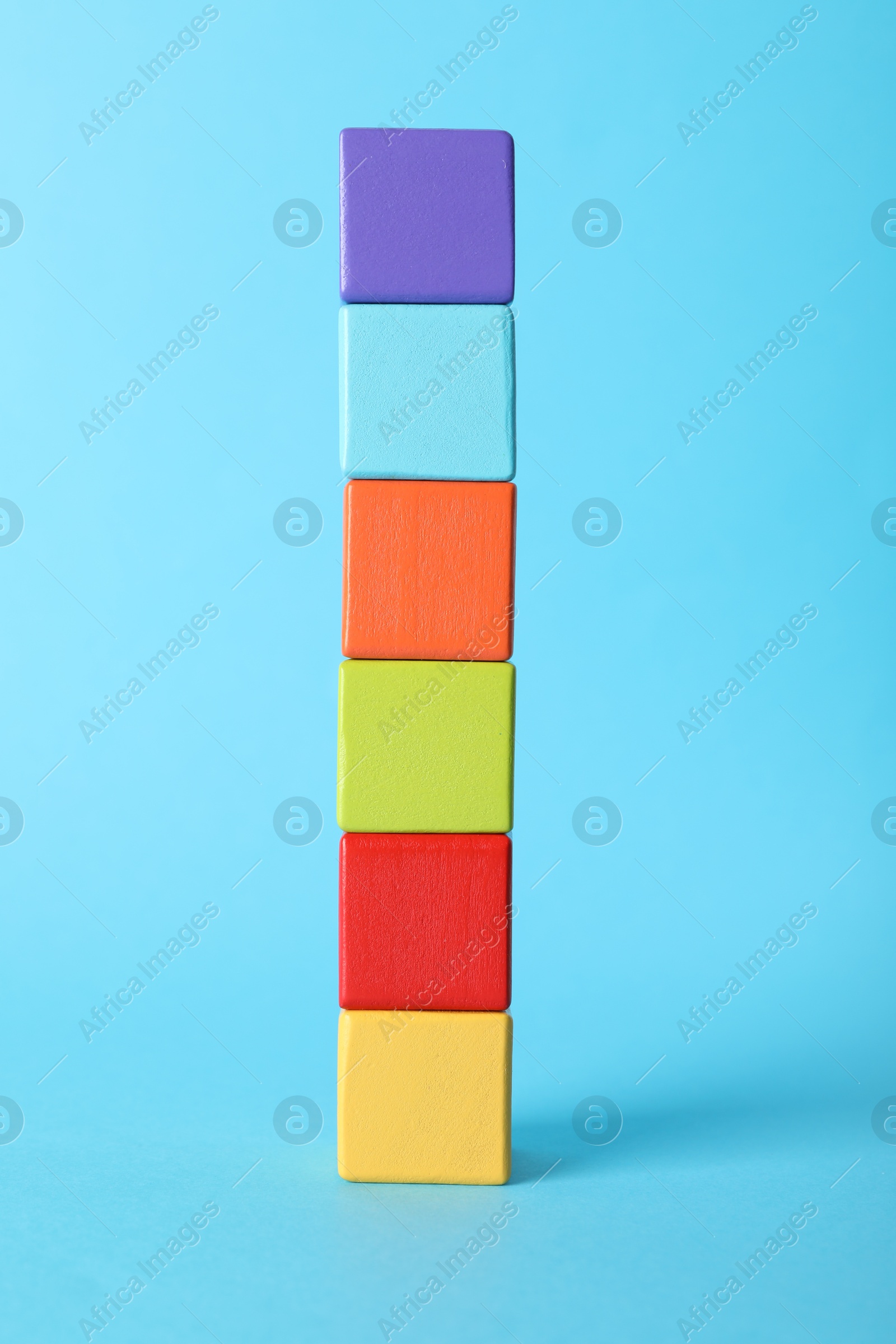 Photo of Colorful wooden cubes on light blue background