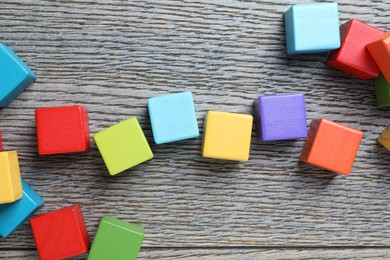 Photo of Colorful cubes on wooden background, top view