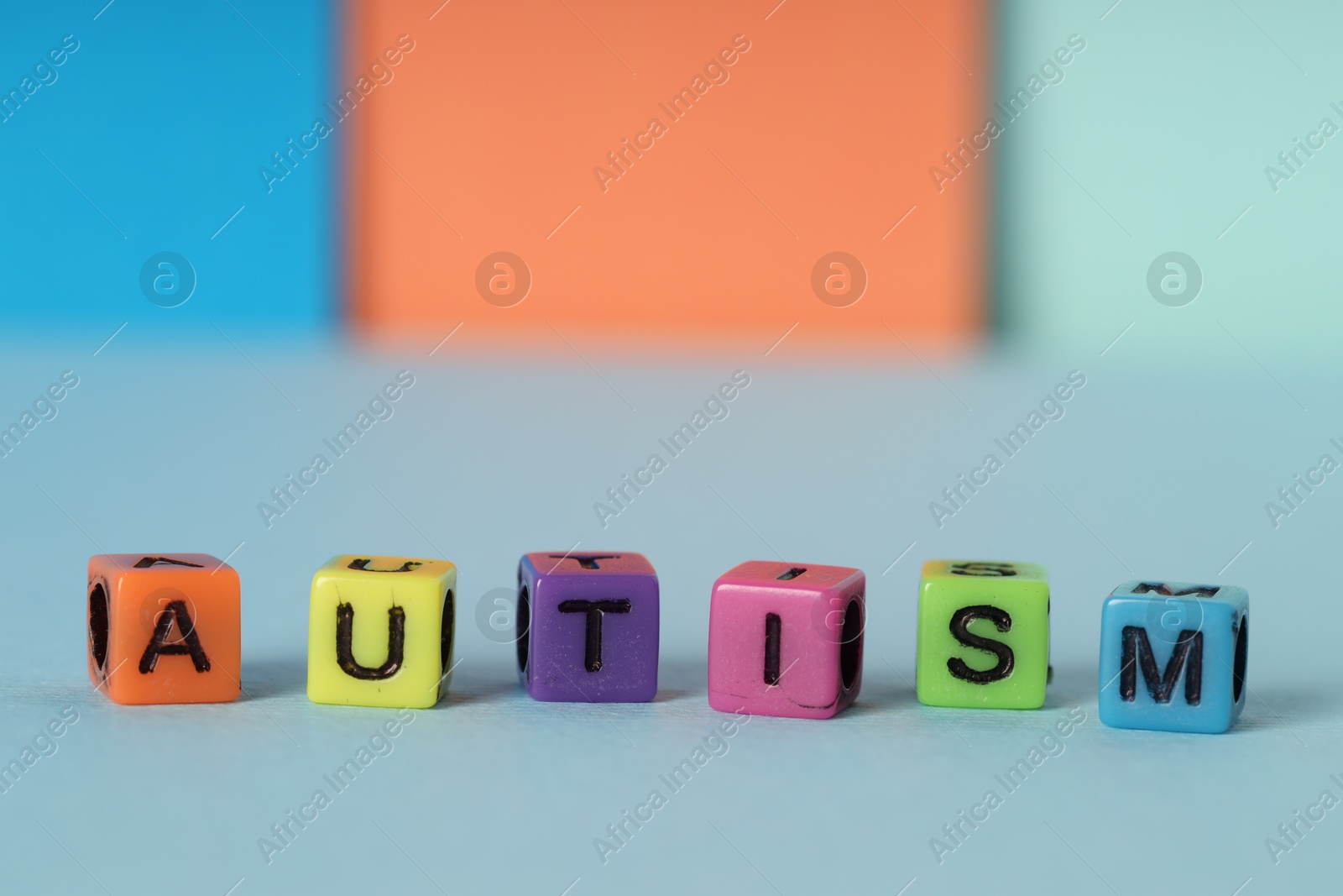 Photo of Word Autism made of colorful cubes on color background