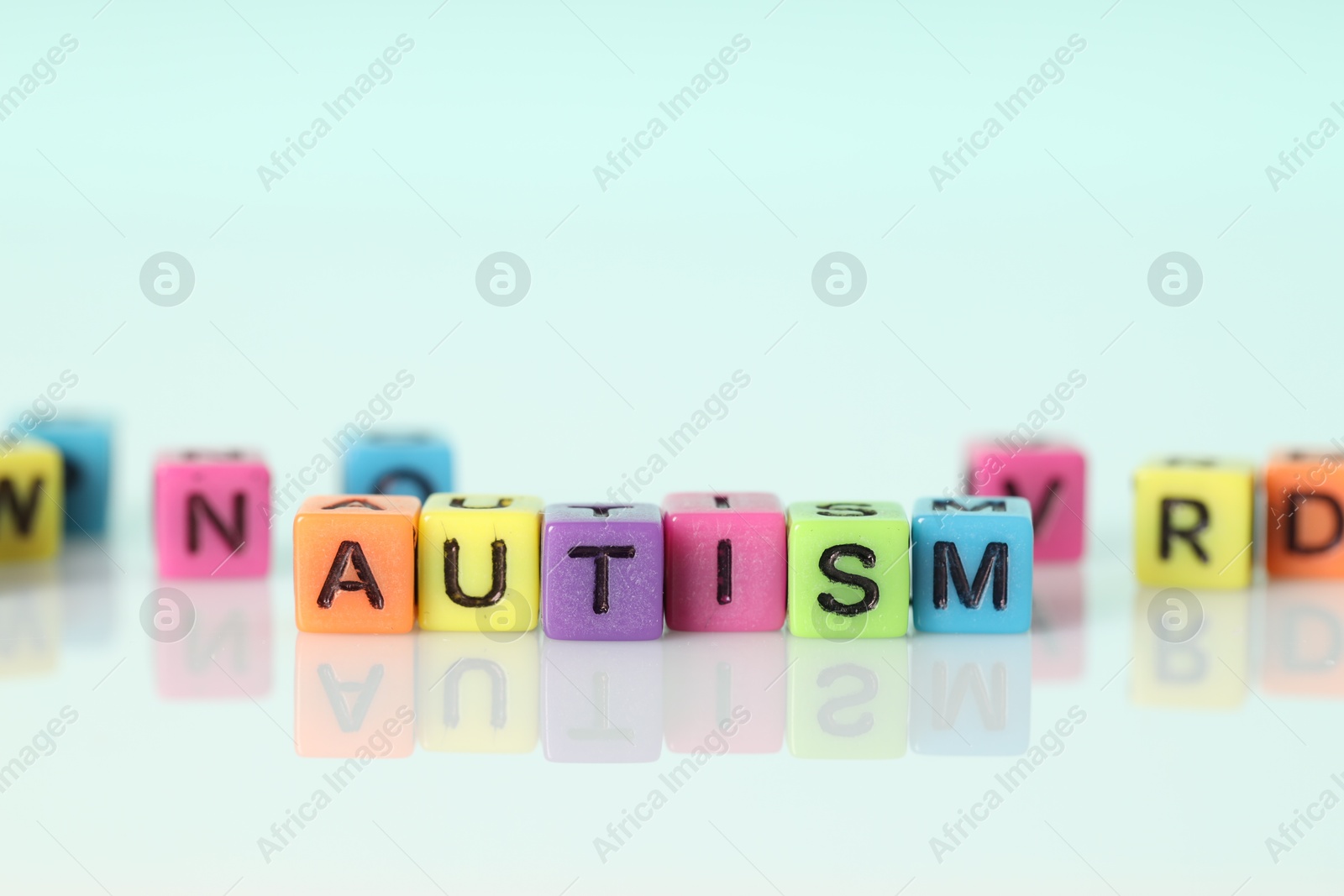 Photo of Word Autism made of colorful cubes on light background