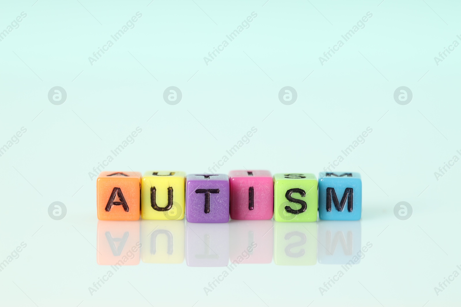 Photo of Word Autism made of colorful cubes on light background