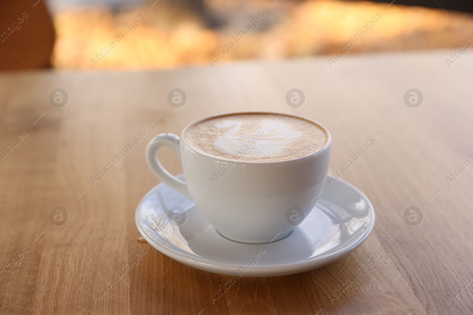 Photo of Cup of aromatic coffee on wooden table in cafe, closeup