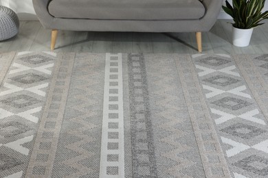 Photo of Stylish soft rug with pattern on floor in living room