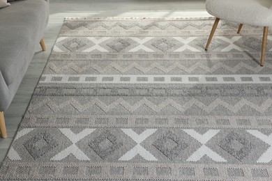 Photo of Stylish soft rug with pattern on floor in living room