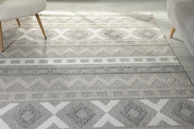 Photo of Stylish soft rug with pattern on floor in living room