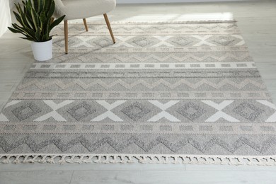 Photo of Stylish soft rug with pattern on floor in living room