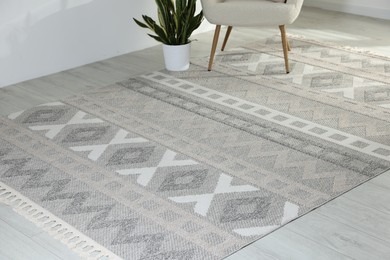 Photo of Stylish soft rug with pattern on floor in living room
