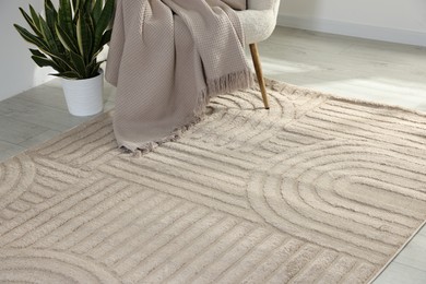Photo of Stylish soft rug with pattern on floor in living room