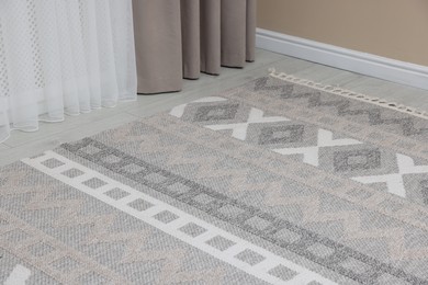 Photo of Stylish soft rug with pattern on floor indoors