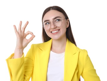 Happy young woman showing OK gesture on white background