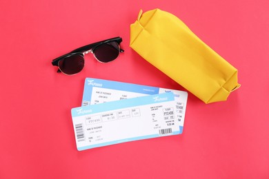 Photo of Airplane tickets, bag and sunglasses on red background, flat lay. Travel abroad