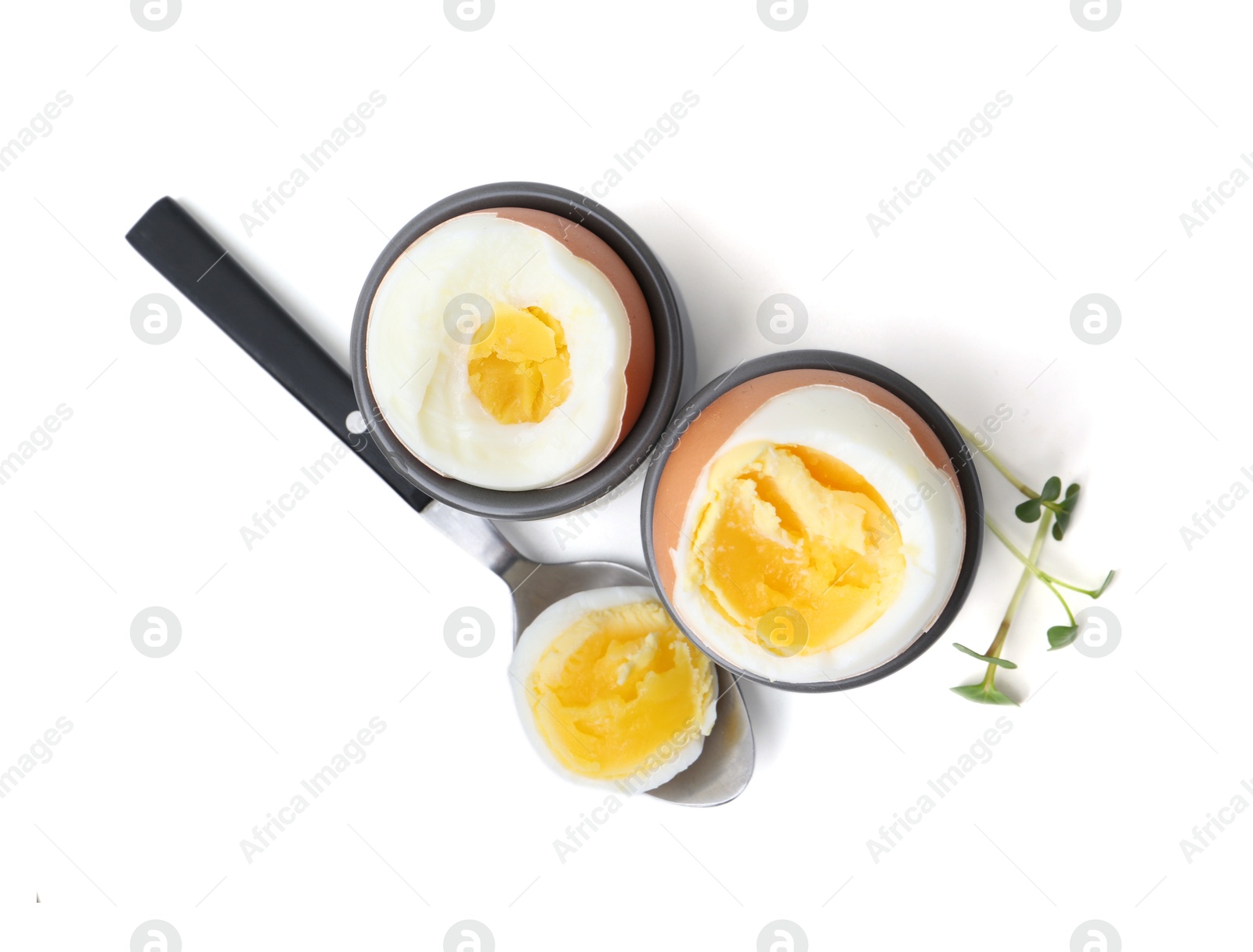 Photo of Soft boiled eggs and spoon isolated on white, top view