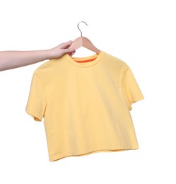 Photo of Woman holding hanger with yellow t-shirt on white background, closeup