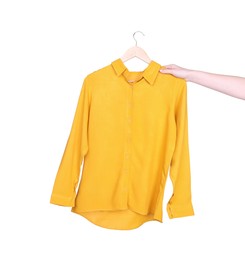 Photo of Woman holding hanger with yellow shirt on white background, closeup