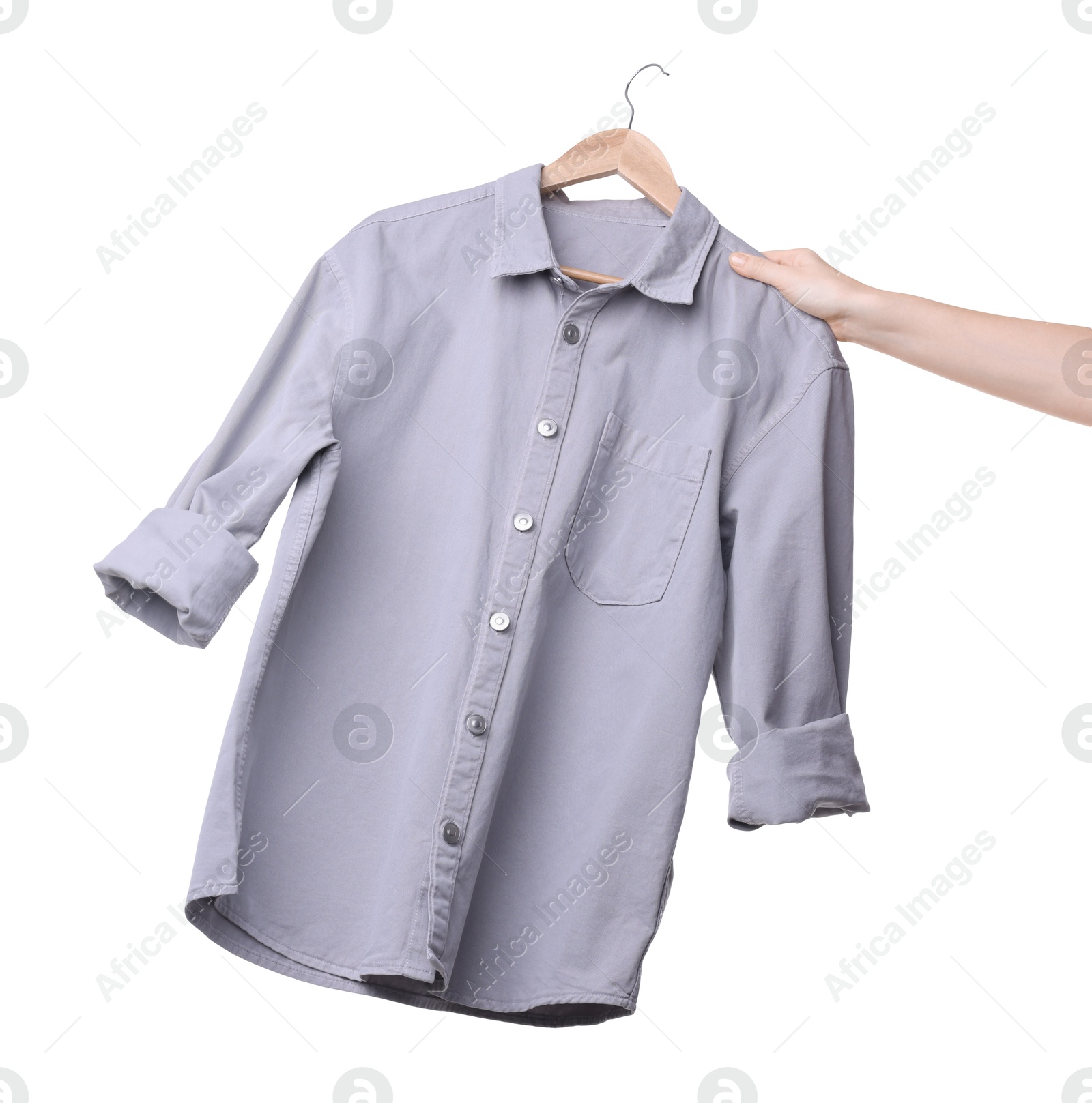 Photo of Woman holding hanger with light grey shirt on white background, closeup