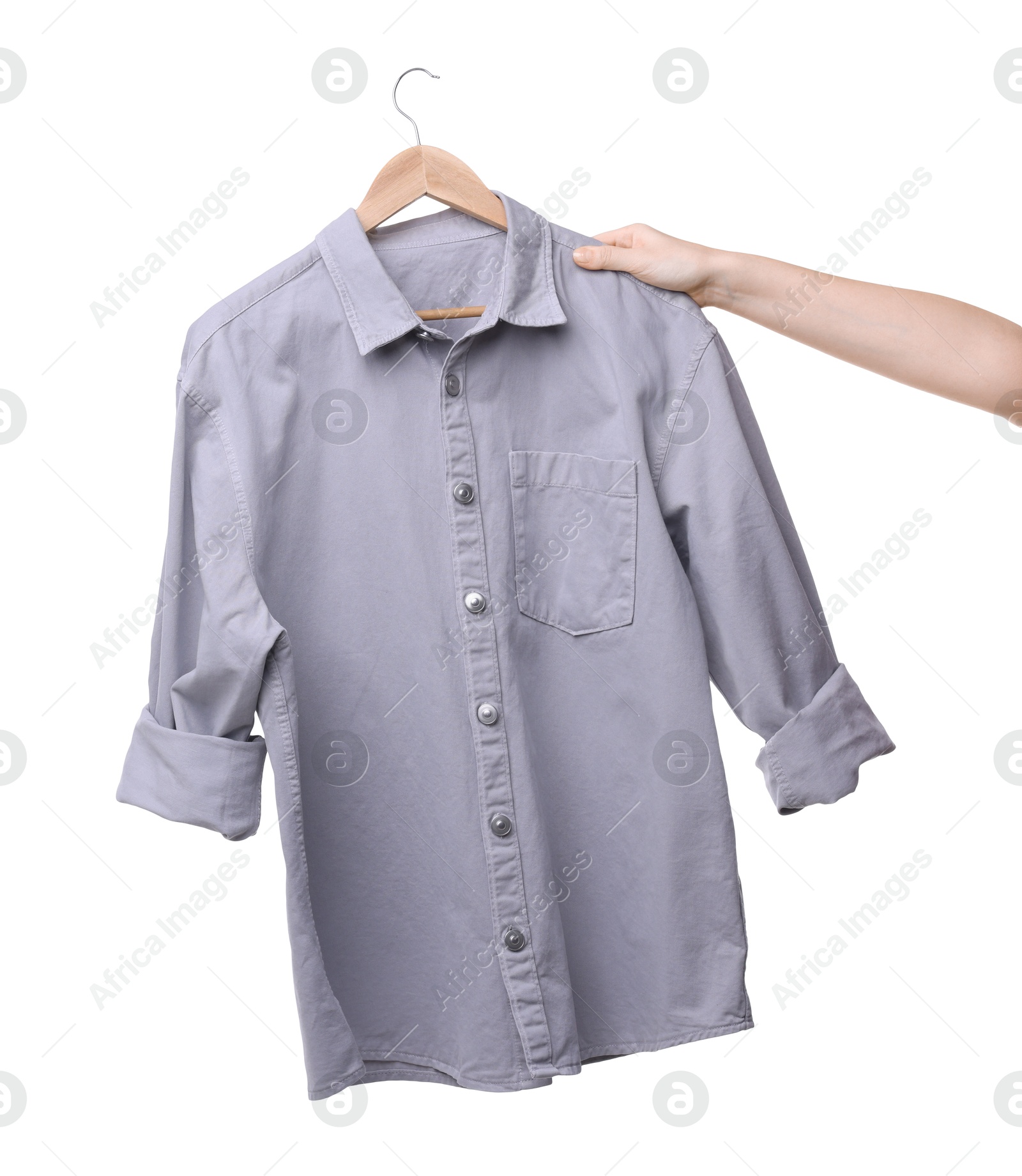 Photo of Woman holding hanger with light grey shirt on white background, closeup