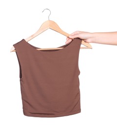 Photo of Woman holding hanger with brown top on white background, closeup