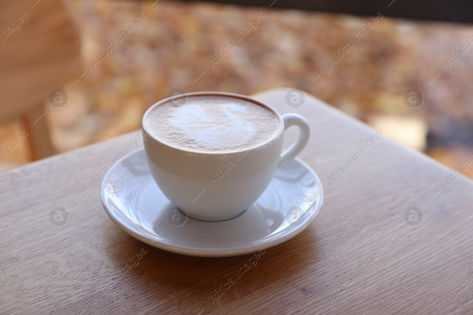 Photo of Cup of aromatic coffee on wooden table in cafe, closeup