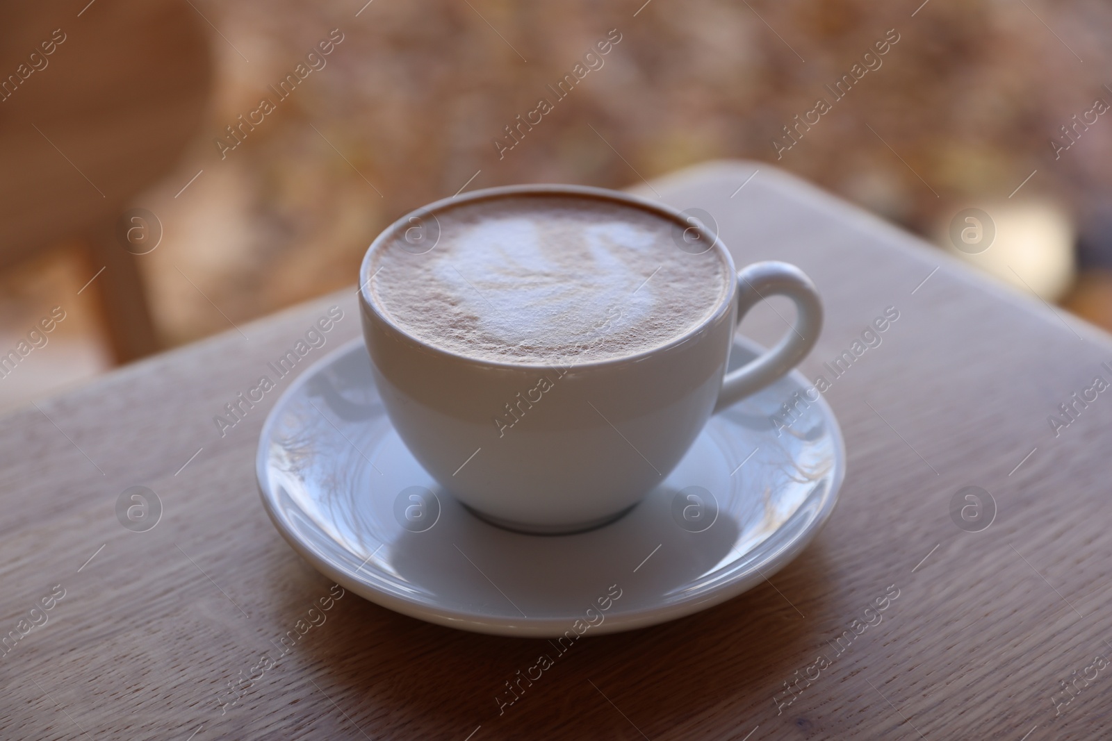 Photo of Cup of aromatic coffee on wooden table in cafe, closeup