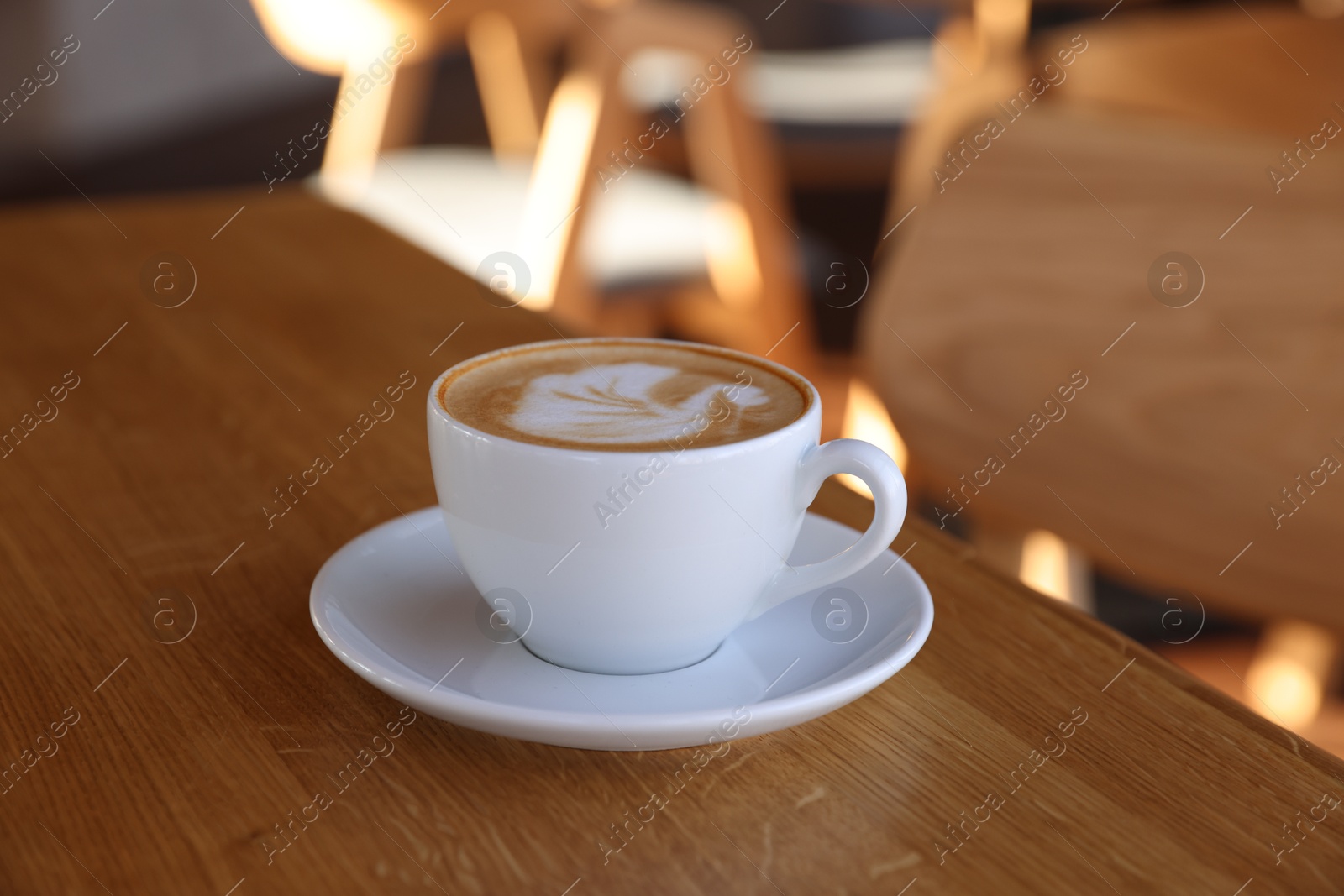 Photo of Cup of aromatic coffee on wooden table in cafe, closeup