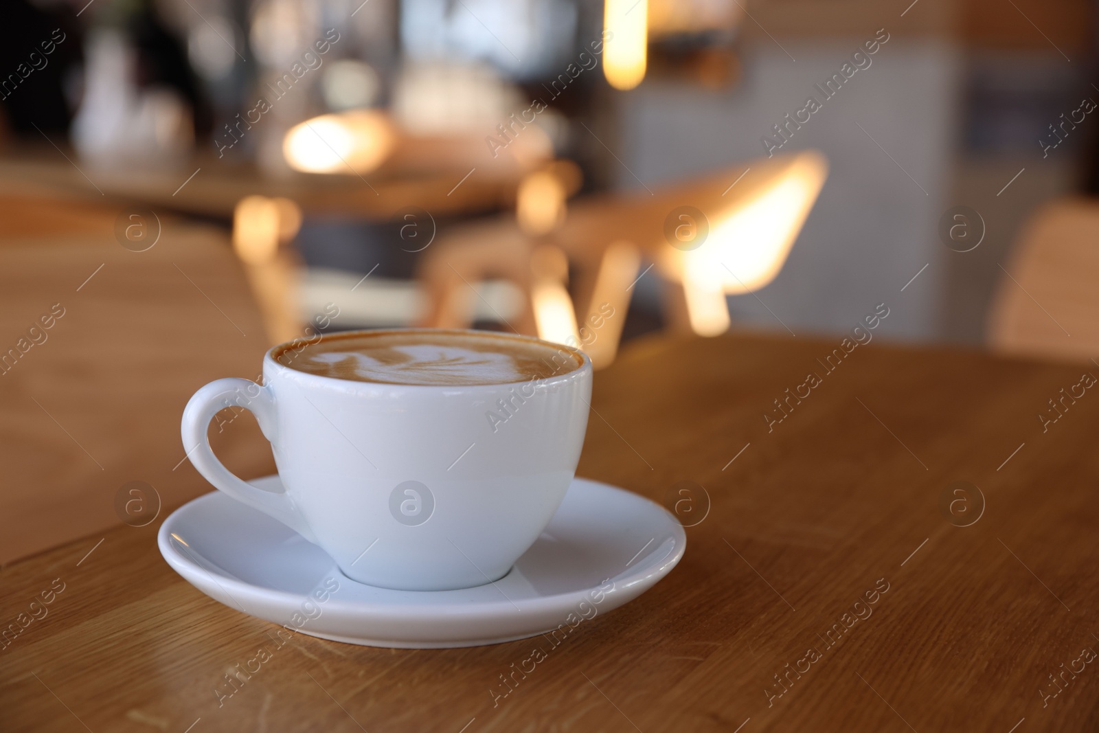 Photo of Cup of aromatic coffee on wooden table in cafe, closeup. Space for text