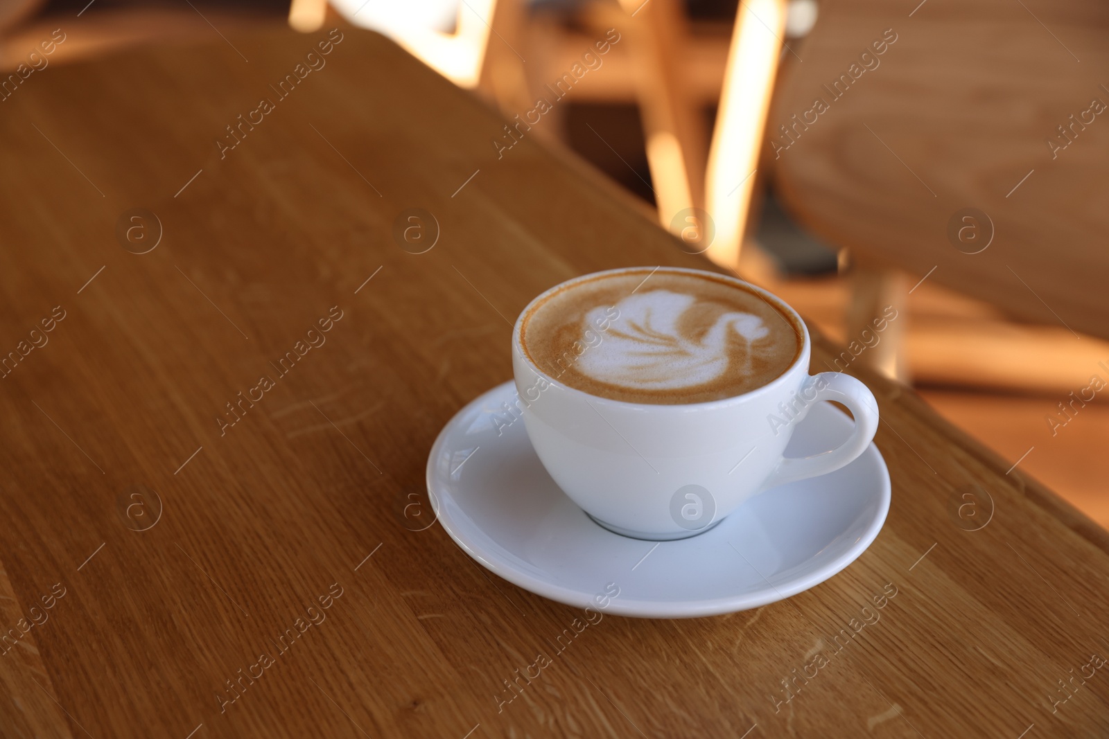 Photo of Cup of aromatic coffee on wooden table in cafe, closeup. Space for text