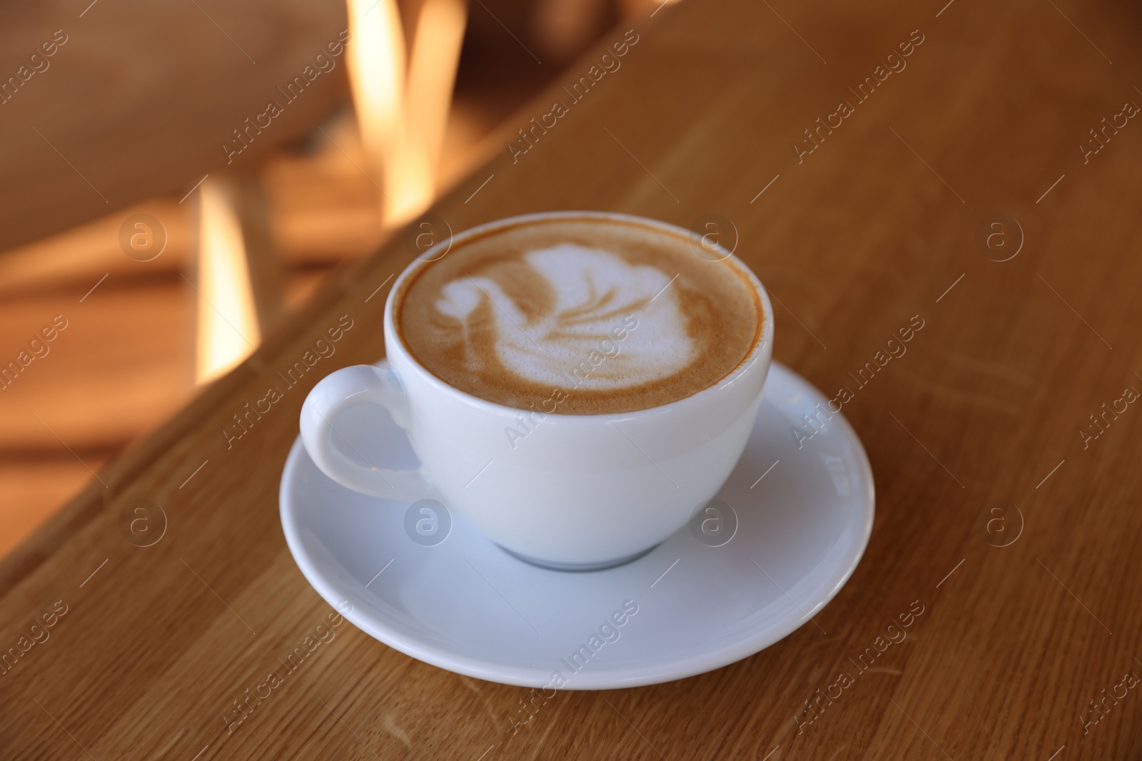 Photo of Cup of aromatic coffee on wooden table in cafe, closeup