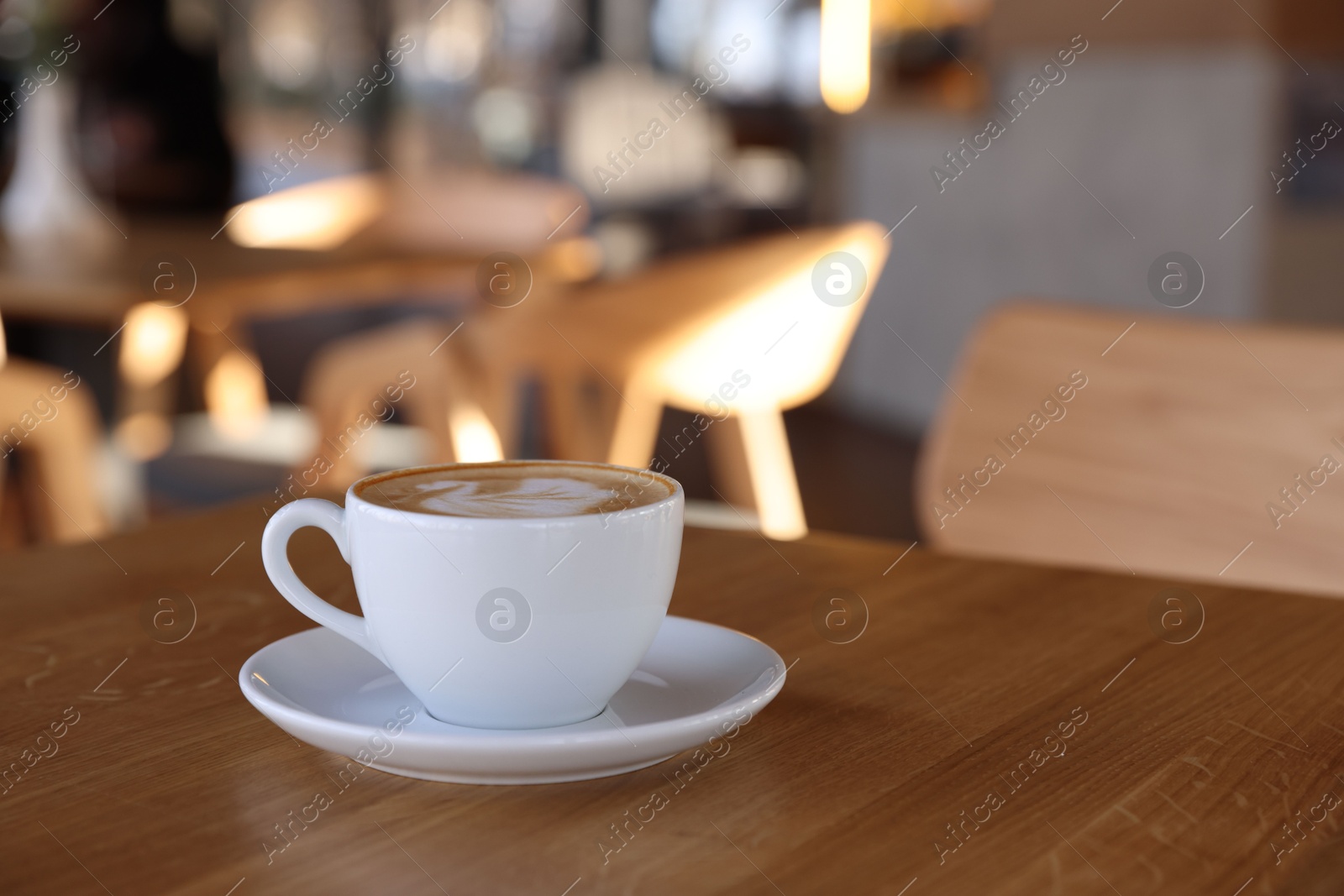 Photo of Cup of aromatic coffee on wooden table in cafe, closeup. Space for text