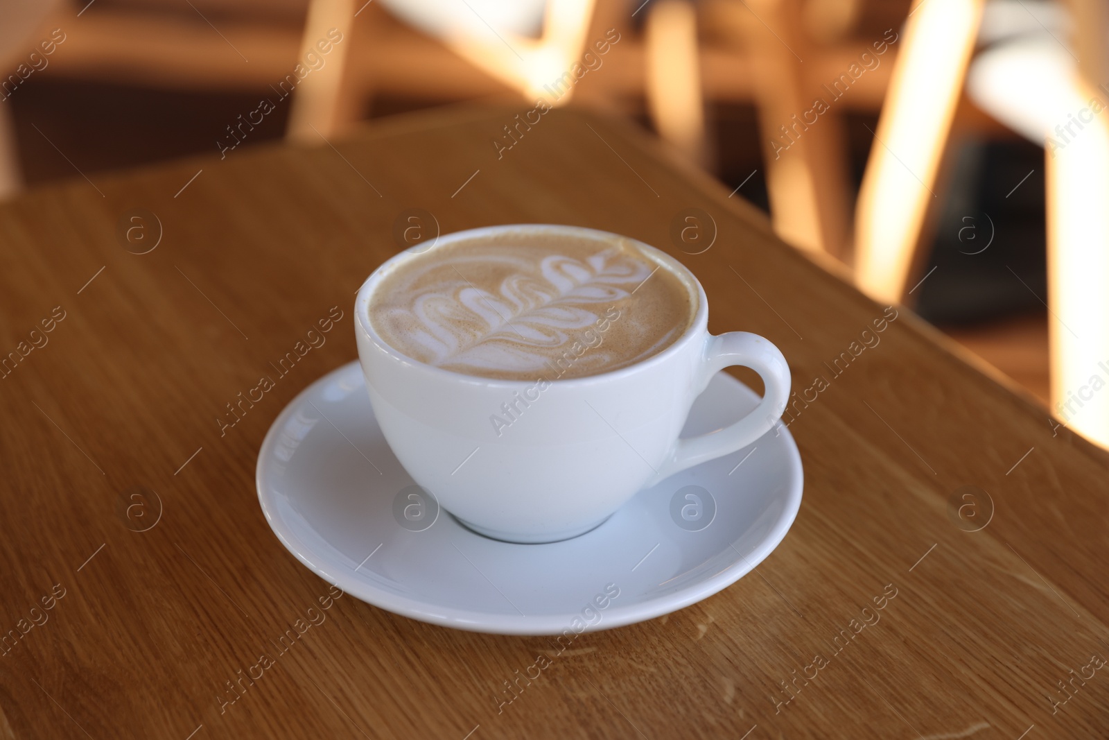 Photo of Cup of aromatic coffee on wooden table in cafe, closeup