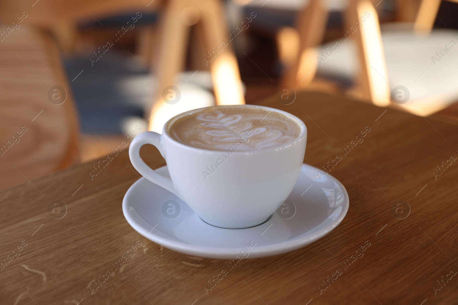 Photo of Cup of aromatic coffee on wooden table in cafe, closeup