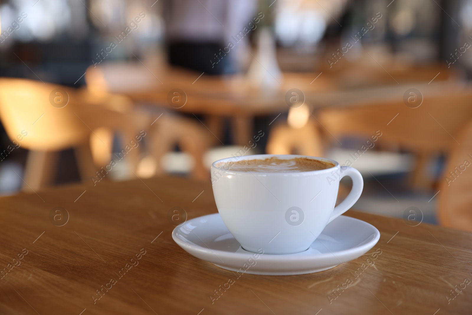 Photo of Cup of aromatic coffee on wooden table in cafe, closeup. Space for text