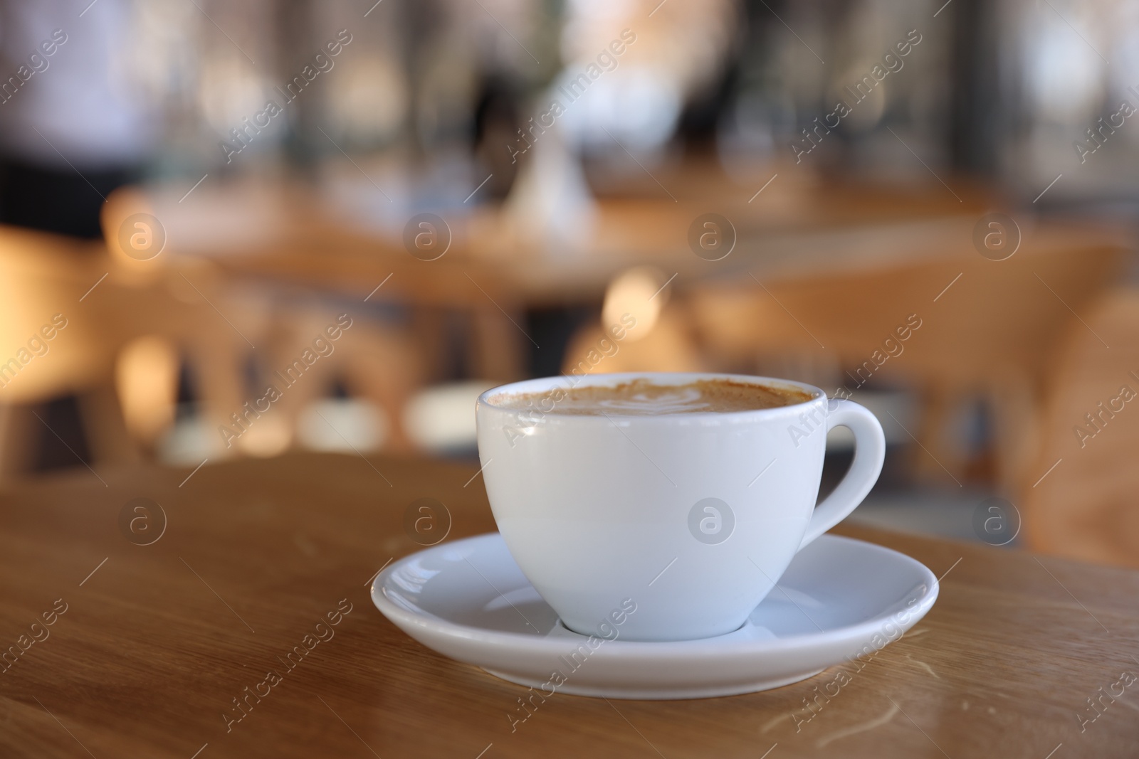 Photo of Cup of aromatic coffee on wooden table in cafe, closeup. Space for text