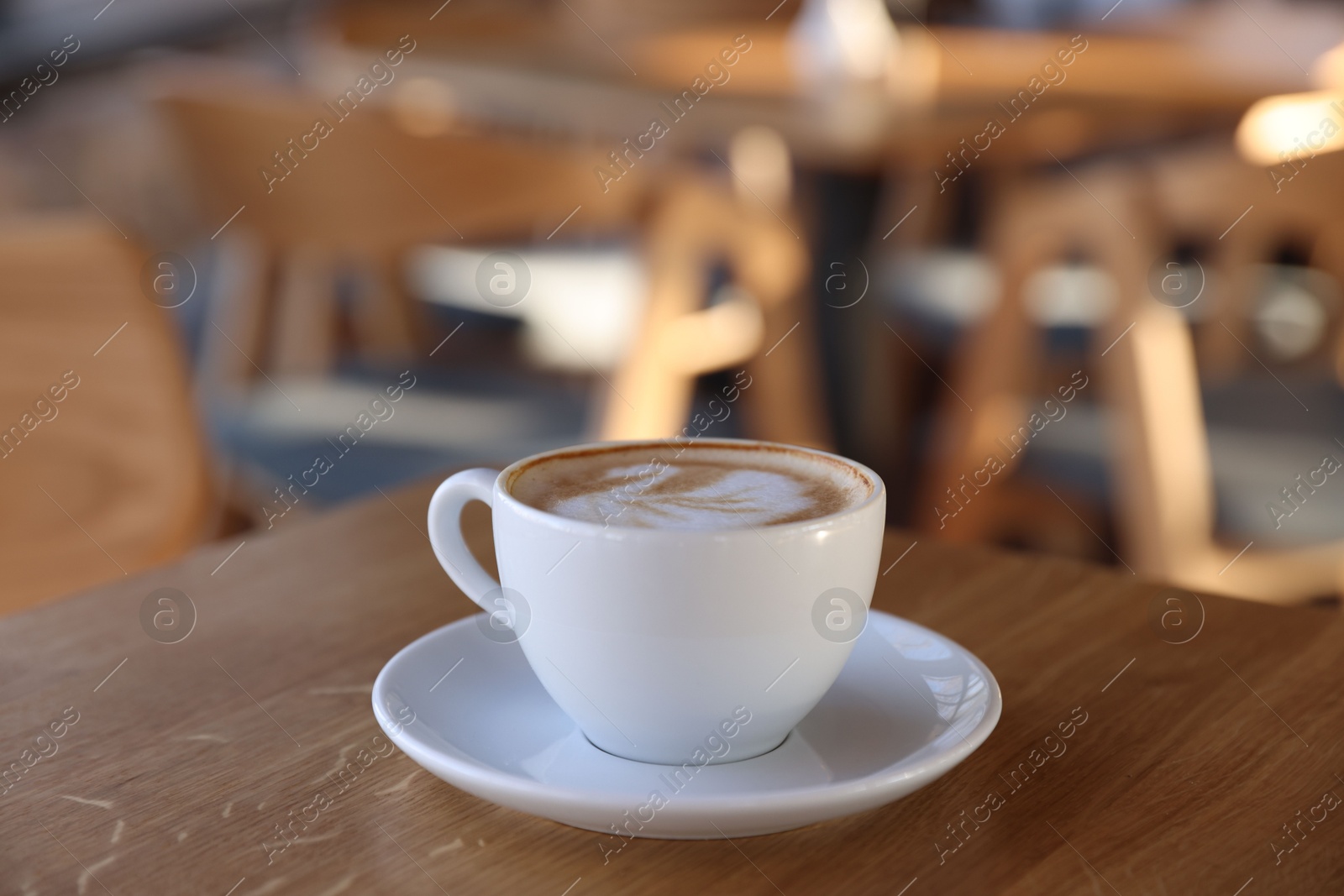 Photo of Cup of aromatic coffee on wooden table in cafe, closeup. Space for text