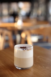 Photo of Glass of aromatic coffee on wooden table in cafe. Space for text