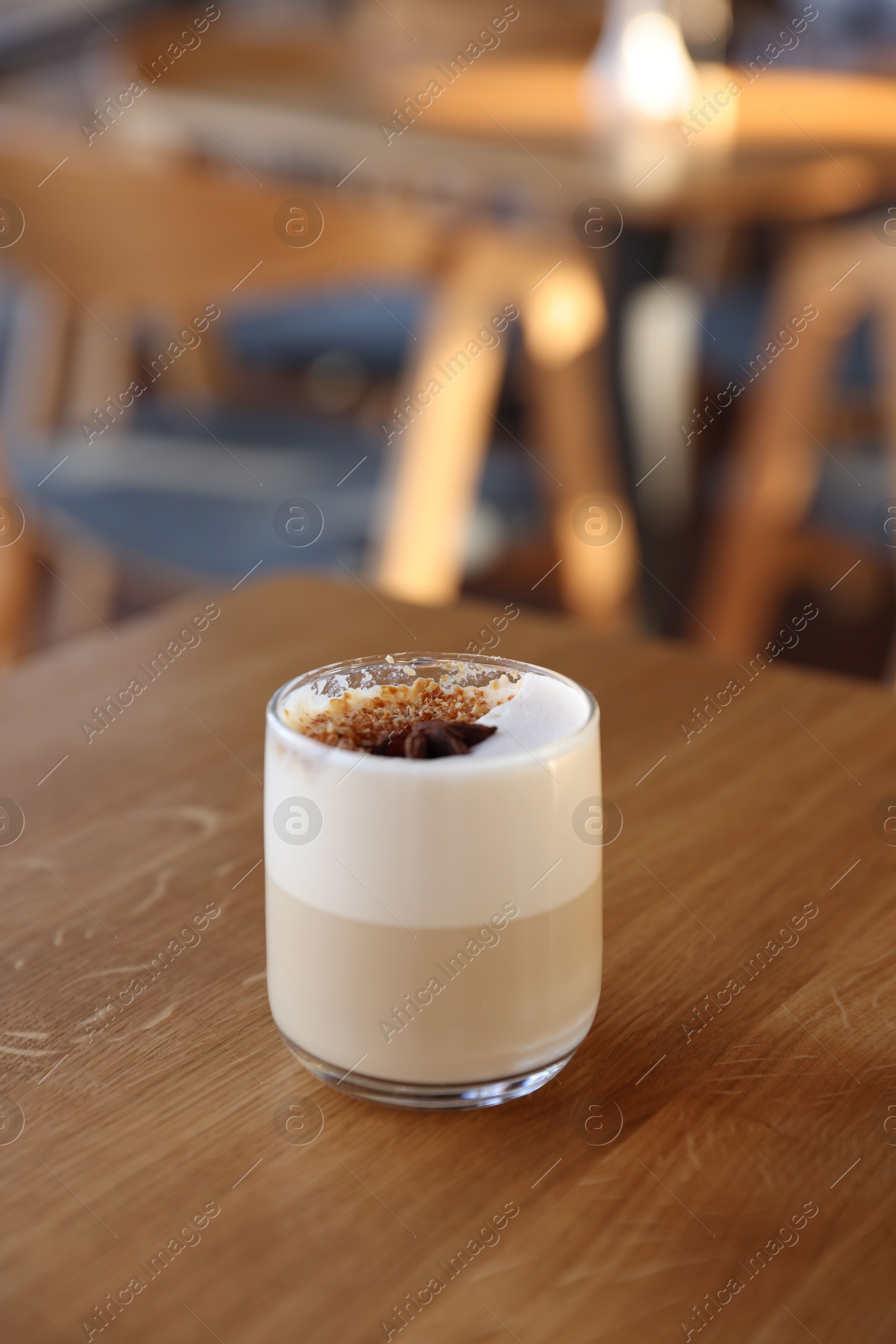 Photo of Glass of aromatic coffee on wooden table in cafe. Space for text