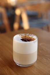 Photo of Glass of aromatic coffee on wooden table in cafe, closeup. Space for text