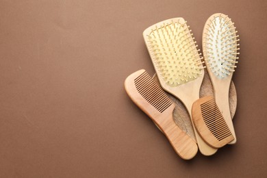 Photo of Wooden hair brushes and combs on dark beige background, top view. Space for text