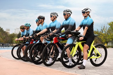 Photo of Group of athletic people with bicycles outdoors