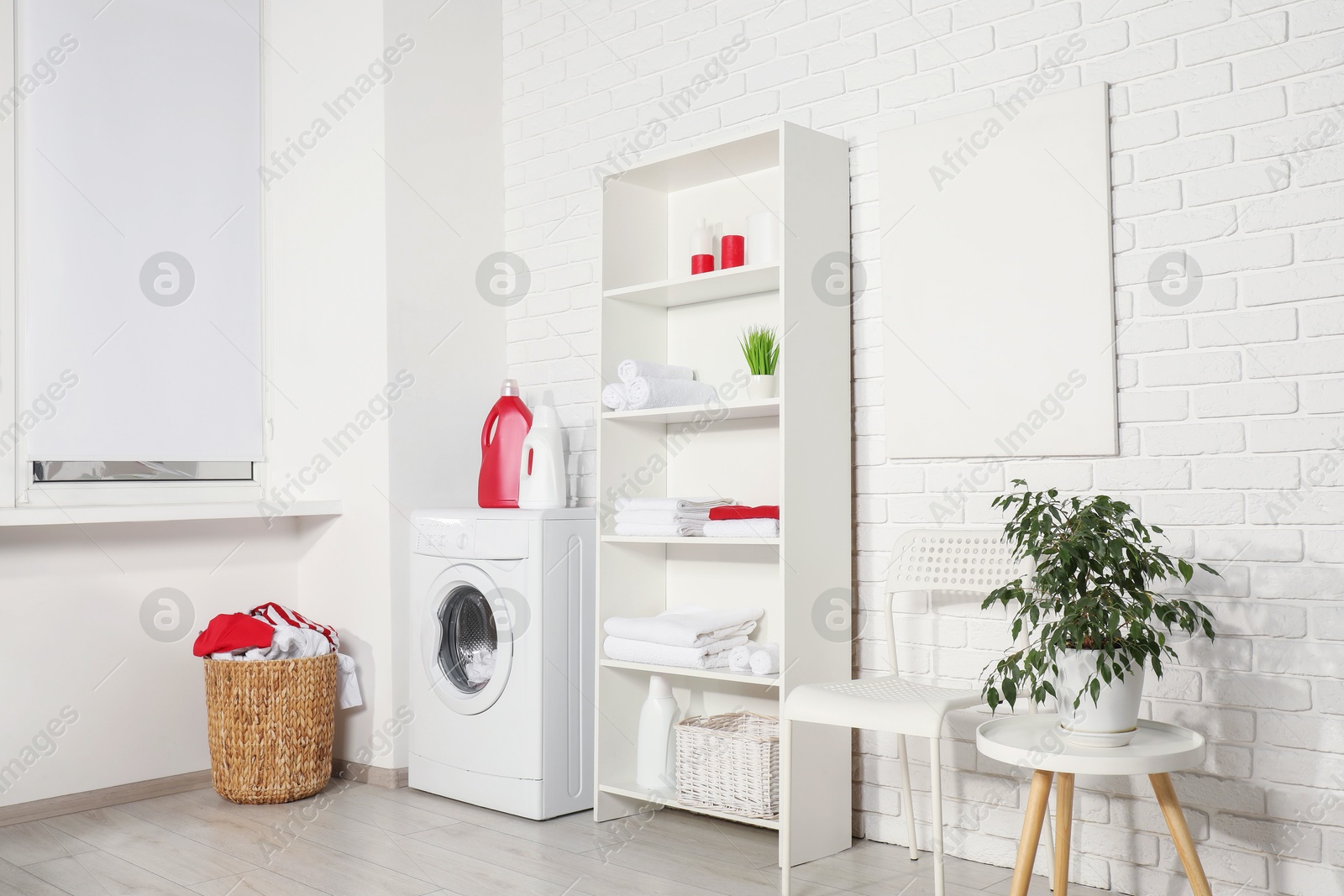 Photo of Washing machine, detergents and basket with laundry in room