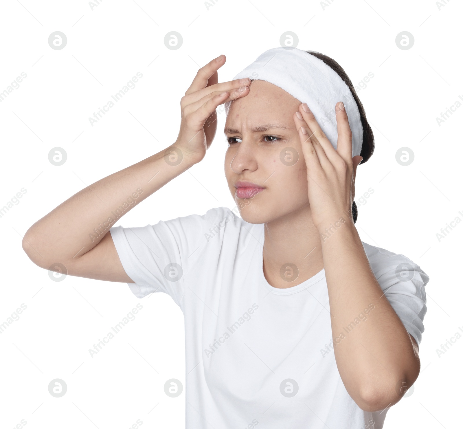 Photo of Upset teenage girl popping pimple on her face against white background. Acne problem