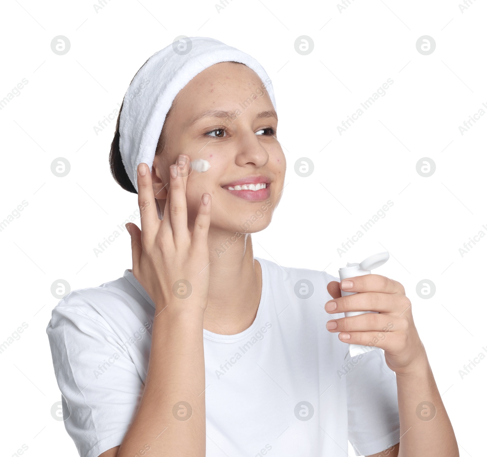 Photo of Teenage girl with acne problem applying cream on white background